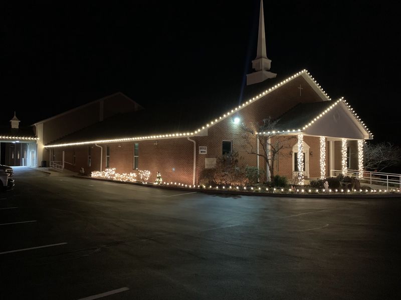 Church with warm white lights on the roofline