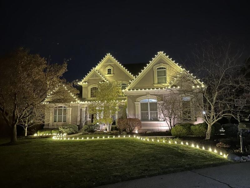 Warm white roofline lights with lighted walkway stakes on a home in Indian Hill, OH