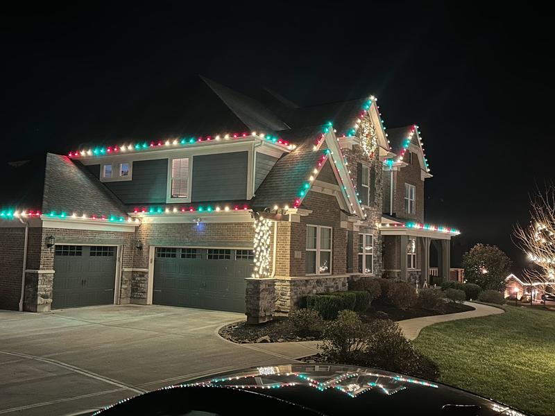 Two-story home with red, green, and white C9 lights on the roofline