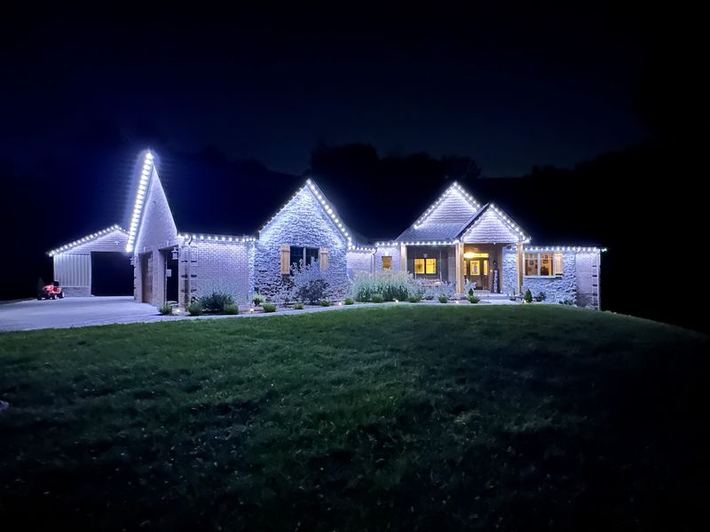 Ranch home with cool white lights on every roof peak